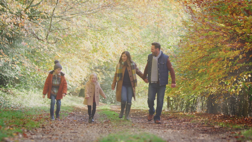 Family walking along track in autumn countryside with children running ahead - shot in slow motion Royalty-Free Stock Footage #1074834632