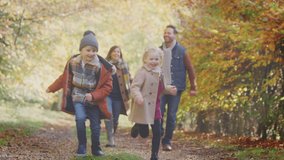 Family walking along track in autumn countryside with children running ahead - shot in slow motion - Powered by Shutterstock - Get 15% off with code: PIKWIZARD15