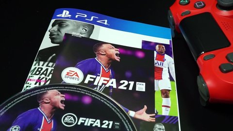 Rome, Italy - June 05, 2021, detail of the DVD of the PS4 game, Fifa 2021, with an image of the footballer Kylian Mbappé and a detail of the red controller.