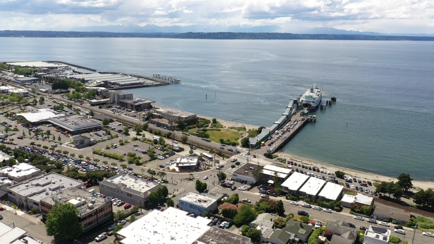 Cinematic 4K drone trucking footage of the downtown Edmonds commercial area, Kingston ferry terminal, Port of Edmonds, waterfront marina, near Seattle, Washington, in Snohomish County