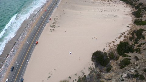 Aerial Drone Shot of Pacific Coast Highway, Ocean Waves While Following Fast Cars