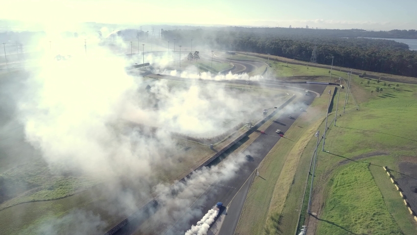 Cars Drifting With Smoke From Burning Tires At The Race Track. Drag Racing At Sydney Motorsport Park In Australia. aerial