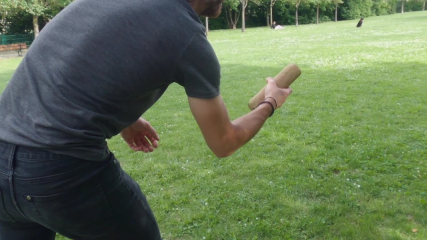 Slow Motion Of Player Throwing Pin And Hits Nothing. Playing Molkky Game In The Lawn At Summer. tracking shot