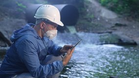 water treatment engineer examines environmental pollution. biologist with digital tablet examines water allergy. worker in a helmet works about environmental pollution. biologist sewage test water app - Powered by Shutterstock - Get 15% off with code: PIKWIZARD15