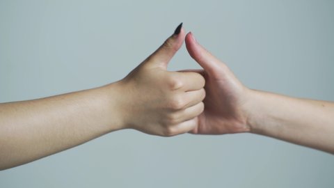 Thumb wrestle between two people. Human arm and thumb wrestling. Woman and man hands playing thumb wars closeup, arm gestures concept. Two hands show gestures, fight with fingers, move. Close up.