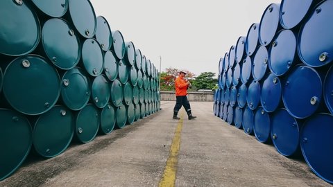 Male worker inspection record drum oil stock barrels blue and green horizontal or chemical for in industry.
