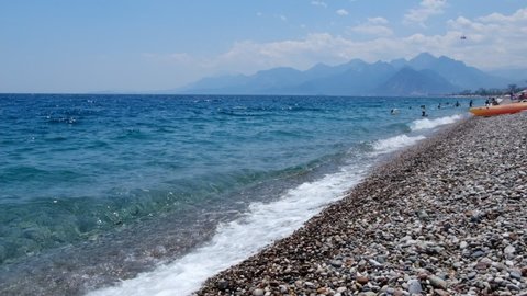 Pebbles and Toros Mountains view of The Konyaalti Beach at Antalya Turkey in slow motion