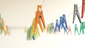 Colorful clothespins for drying clean laundry hang on a clothesline in a row. Copy space