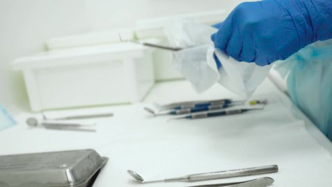 Medical worker preparing cleaning disinfecting medical tools in dentistry. Dental clinic assistant washing stomatological tools with brush and sterilization . Close-up Protection during pandemic