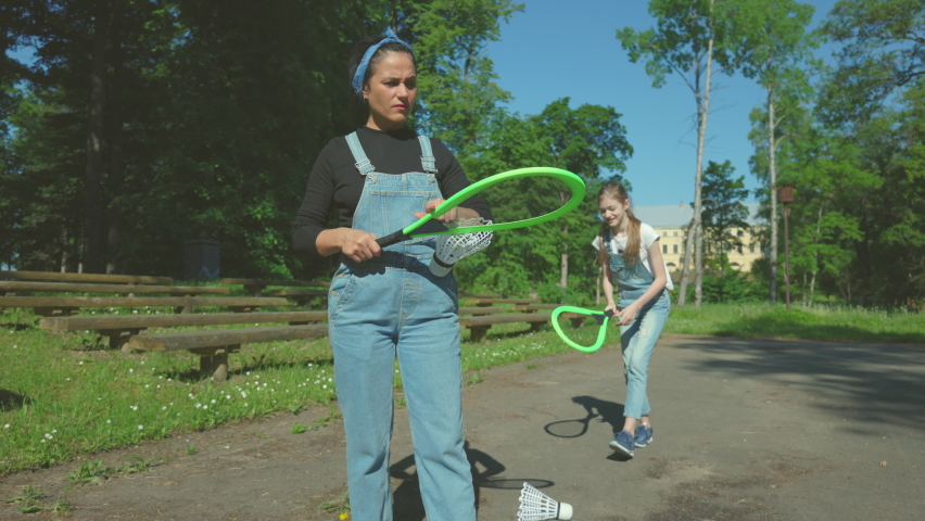 Woman examining badminton racket in park