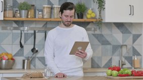 Young Man Doing Video Call On Tablet in Kitchen
