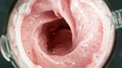 Fresh berries smoothie blended in blender, top view. Healthy eating concept. Super slow motion.
