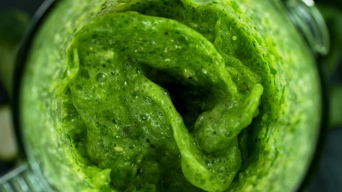 Green fresh smoothie blended in blender, top view. Healthy eating concept. Super slow motion.