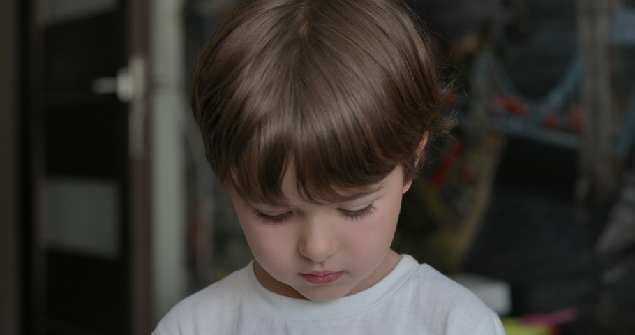 Portrait Little Child Boy Looking at Camera. Young Sad Thinking Curiosity Child Looking at Camera Closeup Indoors. Face Eyes Serious Contemplative Child Close Up. Thoughtful Kid Boy Eyes Thinking.  Royalty-Free Stock Footage #1074892895