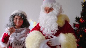 elderly santa claus with his wife congratulates children and adults, shows with hands, concept of christmas, childhood, festive mood, congratulations, good wishes	 - Powered by Shutterstock - Get 15% off with code: PIKWIZARD15