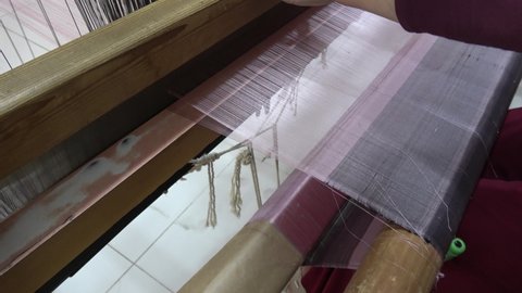 Diyarbakir, Turkey - 16th of June 2021: 4K Viewing the process of silk cloth shawl production with knitting loom
