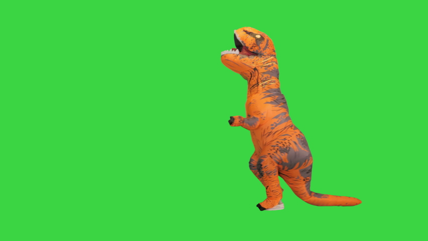 Man in a costume of a dinosaur running after someone on a Green Screen, Chroma Key. | Shutterstock HD Video #1074901652