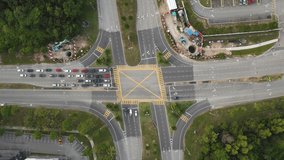 Aerial footage view of a morning traffic scene on a cross junction with small constructions on the junctions. 
