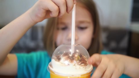 unpacks a straw for drinks to drink a cocktail in a cafe. children's menu. milkshakes and soda. baby food.