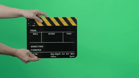 Film Slate or Movie Clapperboard with Blue Green screen background. Film crew man hold and hit film slate in the frame. Clapping film slate. Video production chroma key background. Video production. 