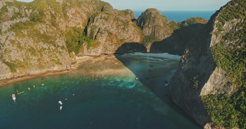 Aerial Maya Bay, Phi Phi island. A turquoise clear water, white sand beach, boats surrounded by limestone mountain. Nature background. Travel destination exotic summer vacation. Cinematic drone flight