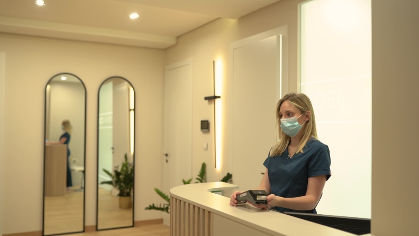 Senior woman paying with credit card at dentist reception Royalty-Free Stock Footage #1074936614