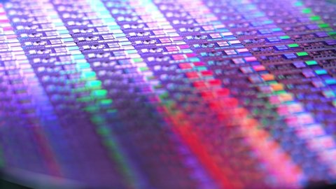 A slowly rotating colorful silicon wafer. Microchips suffered a shortage after the Coronavirus pandemic of 2020.  	