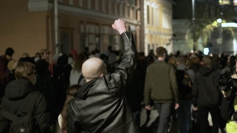 Bald skinhead football hooligan fan probably fascist marching among soccer crowd after game match. Overjoyed provocative behavior foot ball team supporter looks like skin head and fascism aliened.