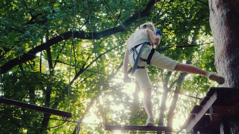 Newbie climber trains on ropes in tree branches