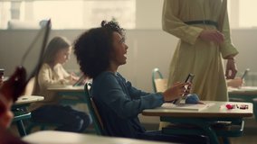 African american girl using digital tablet at school lesson. Smiling schoolgirl browsing internet online. Female teacher walking in classroom. Laughing afro child learning with modern gadget at school - Powered by Shutterstock - Get 15% off with code: PIKWIZARD15