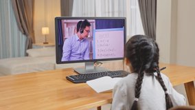 Asian young girl look at virtual video online, learn on laptop at home. Homeschool little kid use computer study and listen to school teacher by digital remote conference meeting due covid19 pandemic.