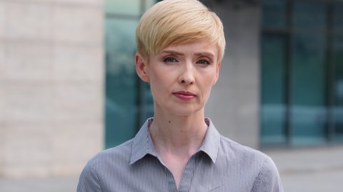 Portrait caucasian mature woman with short hair middle age 40s businesswoman lady standing posing outdoors on street looking at camera shaking head negatively answering no disagree denial prohibition