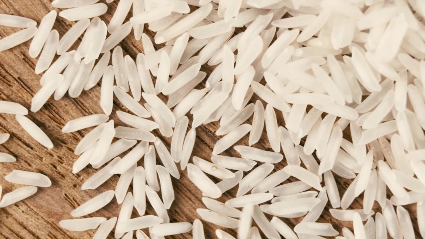 White long rice poured from the top on the table. Healthy grains of chinese national food. Organic uncooked vegeterian ingridient for risotto