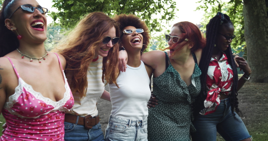 A Group of Multiethnic Young Women Walking in the Park While Embracing Each Other, Talking and Laughing. Diverse Female Friends Celebrating their Femininity and Enjoying their Hang out Outdoors Royalty-Free Stock Footage #1074978542