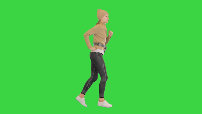 Female runner training jogging outdoors on a Green Screen, Chroma Key.