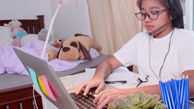 4K Learn from home concept. Asian girl students learning virtual internet online class by remote meeting due to covid-19 pandemic. Girl student learning online with laptop at home