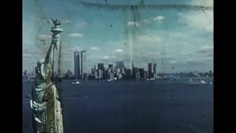 CIRCA 1970 - Excellent view of the Statue of Liberty near the Twin Towers, and ships docked at Chelsea Piers in New York City.