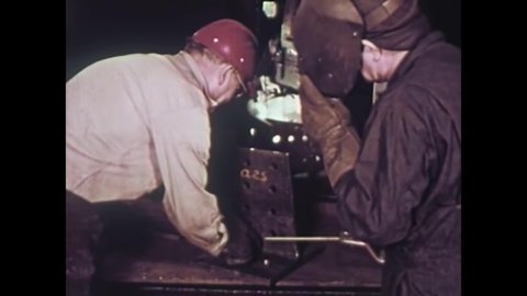 CIRCA 1960 - Welders create steel pieces at a fabricating works facility and a giant crane is used to transport steel beams.