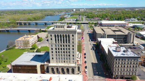 SAGINAW, MICHIGAN - CIRCA 2020s - Good drone aerial of downtown Saginaw, Michigan with old buildings and empty lots, suggesting economic downturn.
