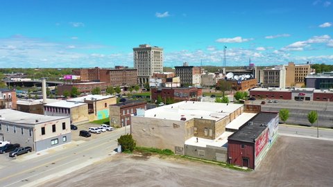 SAGINAW, MICHIGAN - CIRCA 2020s - Good drone aerial of downtown Saginaw, Michigan with old buildings and empty lots, suggesting economic downturn.