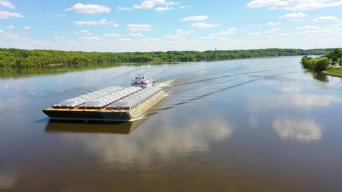 LE CLAIRE, IOWA - CIRCA 2020s - Very good drone aerial along the Mississippi River at Le Claire, Iowa of old riverboat and barge heading upstream.
