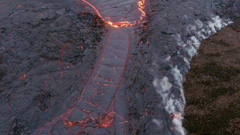 ICELAND - CIRCA 2020s - Top down high angle drone aerial of molten lava fields and snow falling at the Fagradalsfjall volcano eruption in iceland.