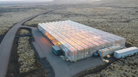 ICELAND - CIRCA 2020s - Very good aerial establishing shot of a remote geothermal experimental greenhouse in a lonely section of Iceland.