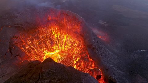 ICELAND - CIRCA 2020s - Amazing night drone aerial high view of active volcano crater Fagradalsfjall volcano with lava boulders falling in in Iceland.