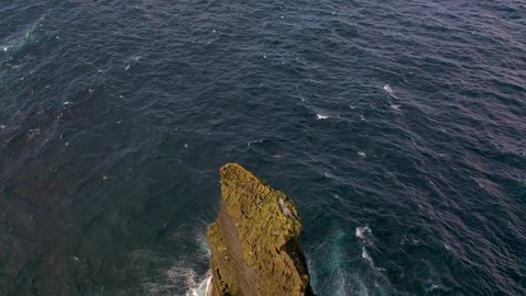 ICELAND - CIRCA 2020s - Remarkable aerial of the Pridrangaviti lighthouse perched on a remote rocky island in the Atlantic ocean.