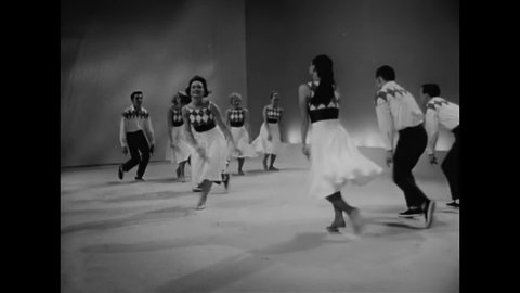 CIRCA 1956 - Couples dance and clap together in a revue.