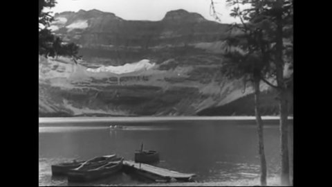 CIRCA 1930s - Tourists drive on the Going-to-the-Sun Road in Montana's Glacier National Park and enjoy mountainous vistas.