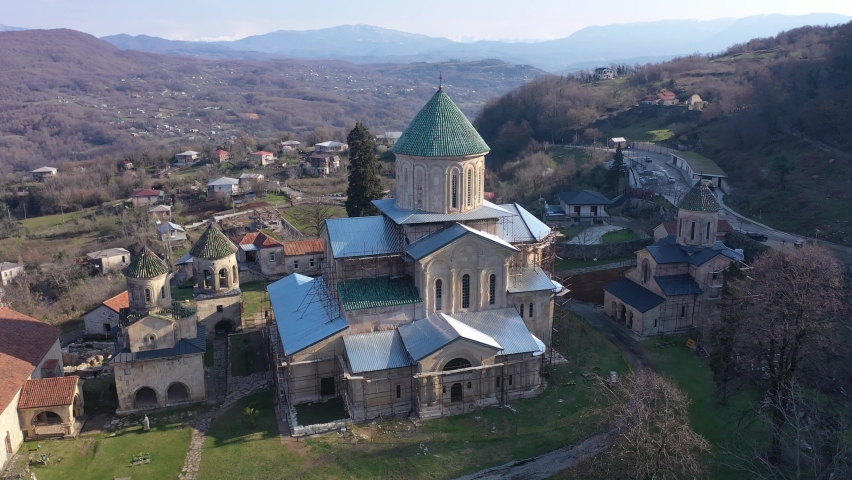 Aerial view of architectural complex of Gelati Monastery with three churches, free standing bell tower and academy building located near Kutaisi on spring day, Georgia