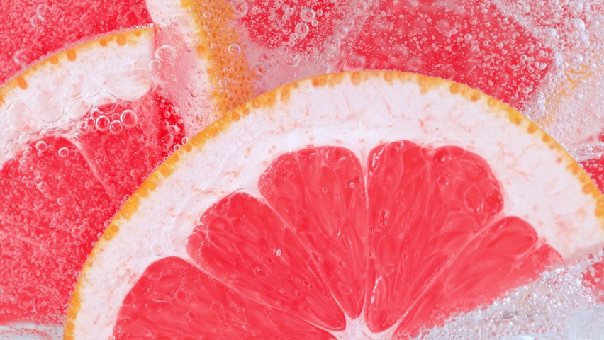 Super Slow Motion Shot of Fizzing Water with Grapefruit Slices and Ice Cubes in Glass at 1000 fps. Royalty-Free Stock Footage #1075015493