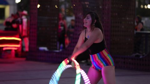 Reno, NV - USA - June 26 2021: Street Performer with Two Colorful Lighted Hula Hoops at the Sierra Arts Festival in Downtown.  Shallow Depth of Field